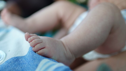 Close-up of feet of a newborn baby. Legs of a small child.