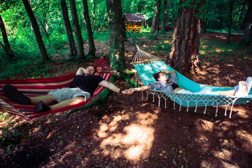 couple laying in hammocks in forest