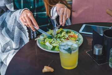 woman in cafe eating salad hands close up no face