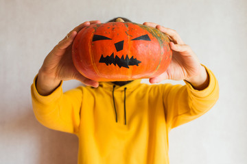 Halloween pumpkin. Man holding in hand a scary face pumpkin. Happy Halloween party holiday....