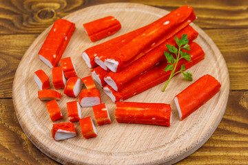 Crab sticks on cutting board on wooden table © olyasolodenko
