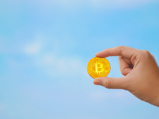 Fototapeta na wymiar Hand Holding Bitcoin to the Sky