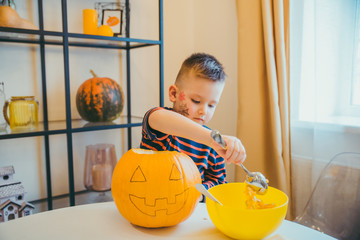 little boy makes halloween pumpkin head at home
