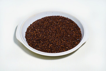 Red or brown Sesame seeds isolated in a pot on white background