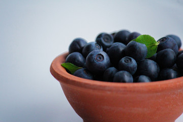 in clay plate on the table berries fresh, useful, tasty blueberries. close up