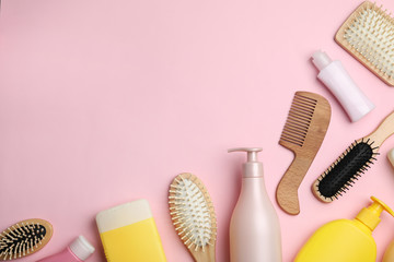 Flat lay composition with hair cosmetic products and tools on pink background. Space for text