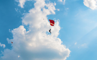 A men flying in the blue sky using parachute
