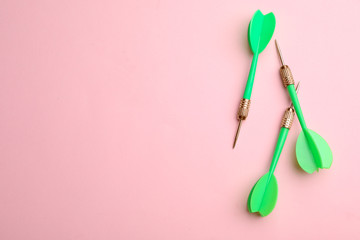 Green dart arrows on pink background, flat lay with space for text