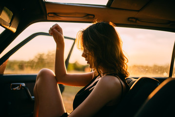 A woman enjoying the sun in her car.