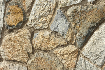 A stone wall of raw stone. Texture of stone. Stone wall.