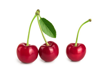 Three cherries with leaf closeup isolated on white background