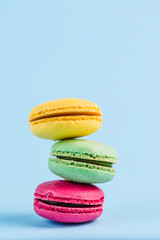 Colorful macaroons on a blue background, close-up, Flatley with copy space