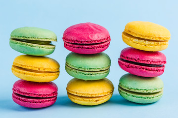 Colorful macaroons on a blue background, close-up, Flatley with copy space