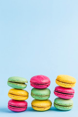 Colorful macaroons on a blue background, close-up, Flatley with copy space