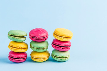 Fototapeta na wymiar Colorful macaroons on a blue background, close-up, Flatley with copy space