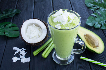 Smoothies with avocado, coconut milk and celery  on the tropical background