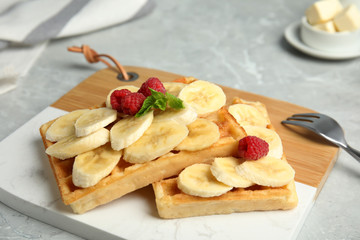 Delicious waffles with fresh berries served on white marble table