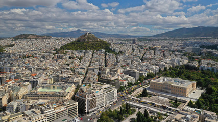 Obraz premium Aerial photo of famous Greek Parliament building in Syntagma square and Lycabettus hill at the background with beautiful clouds and deep blue sky, Athens, Attica, Greece