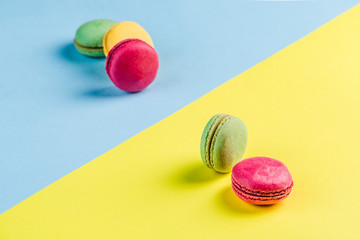 Multicolored macaroons on a blue and yellow background, top view, Flatley with copy space