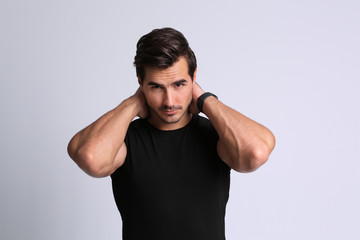 Portrait of handsome young man in black t-shirt on grey background
