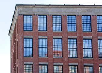 Old restored brick building facade with reflections in windows