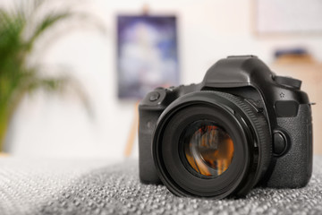 Professional digital camera against blurred background. Space for text