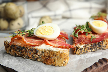 Cutting board of delicious bruschettas with prosciutto on table, closeup