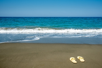 Yellow sandals on a golden sandy beach