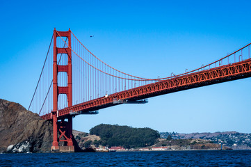 A view of the Golden Gate Bridge towering overhead as seen from the water.
