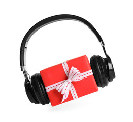 Gift box with headphones isolated on white. Christmas music concept