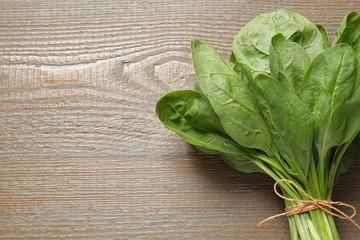 Bunch of fresh green healthy spinach on wooden table, top view. Space for text