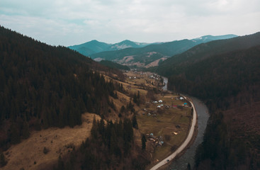 Village in carpathian mountains road and river on foreground