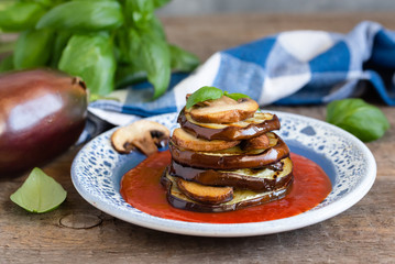 Turrets of grilled eggplants and mushrooms with tomato sauce.