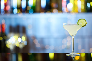 Glass of fresh alcoholic cocktail on bar counter. Space for text