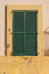 Fototapeta na wymiar closed green window shutters in an old Mediterranean house