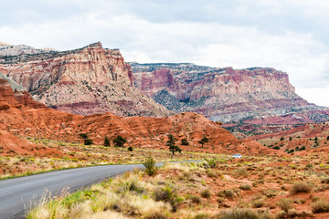 Car on road highway in Capitol Reef National Monument with paved street and colorful stone and cliffs