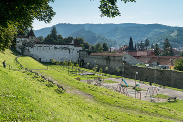 Summer park at the Promenada de sub Tampa with a view on a The Weavers' Bastion in Brasov, Romania