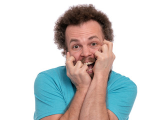 Portrait of screaming bearded man with funny Haircut bites his nails and looks worried. Scared crazy man, isolated on white background. Guy afraid and shocked. Emotions and signs concept.