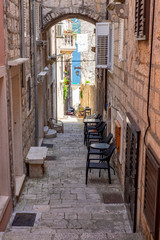 Fototapeta na wymiar Famous narrow stone street with stone houses and facades in historic fortified Korcula town, Korcula Island, Dalmatia, Croatia