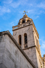 View on exterior of St. Mark’s Cathedral, bell tower and blue sky in the centre of historic old town of Korcula, Korcula Island, Dalmatia, Croatia 