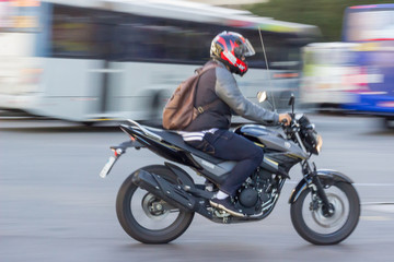 Panning picture of a motorcycle man crossing the streets. Blurred movement effect. Rio de Janeiro,...