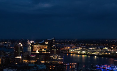 Fototapeta na wymiar View of the harbor and the new Elbphilharmony of Hamburg with boats at night