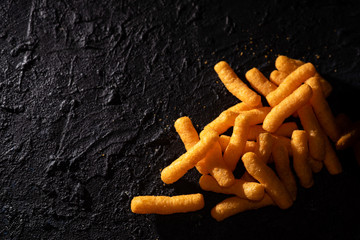 Snacks, crochets or cheese puff pastry on dark background