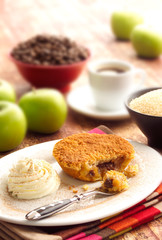 Individual Apple Crumble pie with Cream on plate in table setting
