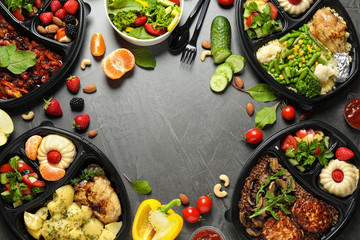 Frame made of lunchboxes on grey table, top view with space for text. Healthy food delivery