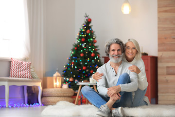 Obraz na płótnie Canvas Happy mature couple celebrating Christmas at home