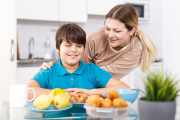 Mother and son eating at kitchen