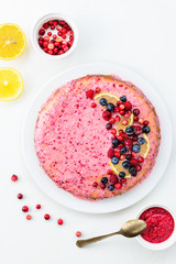 Cranberry pie with lemon on a white table. Top view, vertical orientation, closeup.
