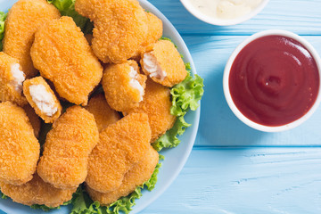 Chicken nuggets in plate on rustic background