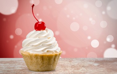 Cupcake with whipped cream and cherry isolated on background